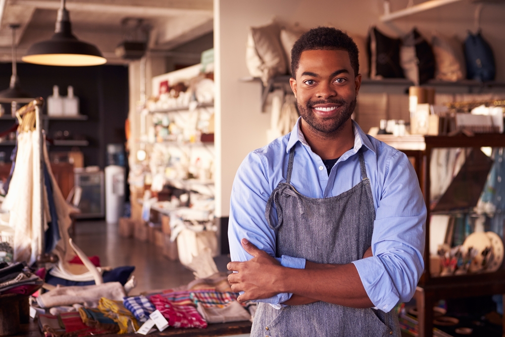 small business owner standing in his gift shop with arms crossed