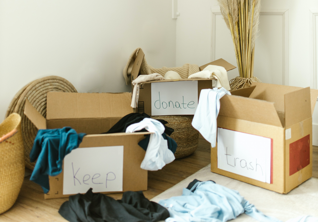 cardboard boxes of keep, donate, trash items for winter decluttering