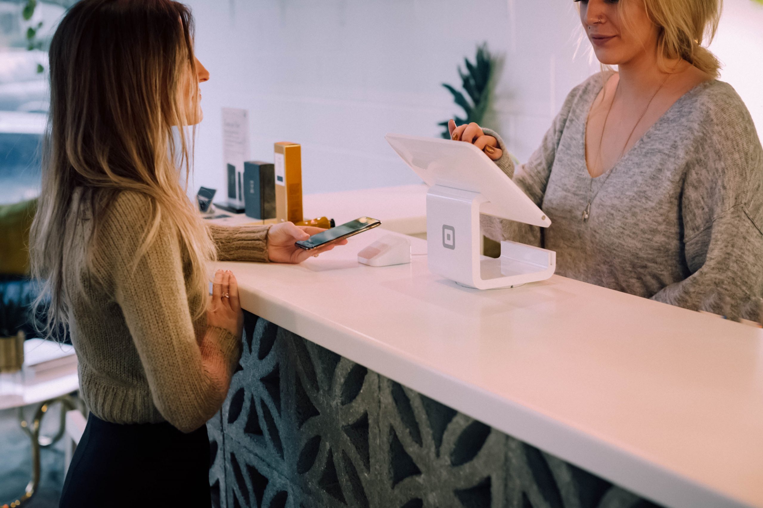 Two women discussing a buy now pay later plan at a check-out counter