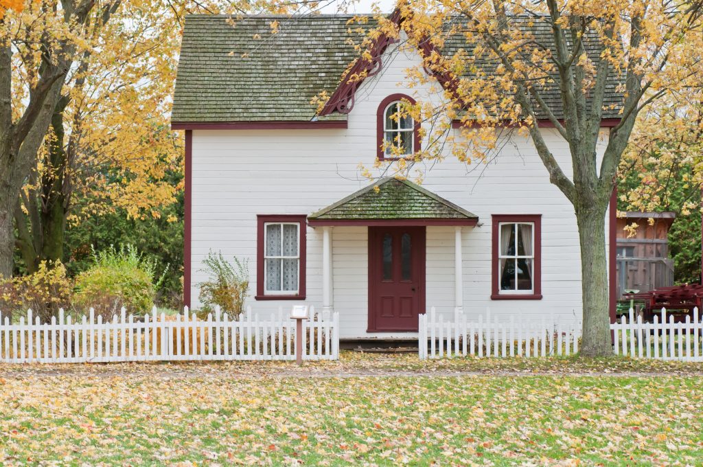 The exterior of a small house with a white picket fence on a blog about mortgage loan changes