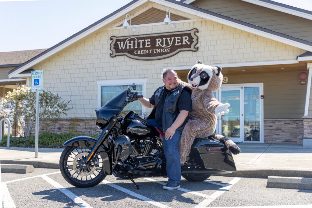 Rocky the raccoon and a local biker sitting on their motorcycle on a blog about car and motorcycle loans