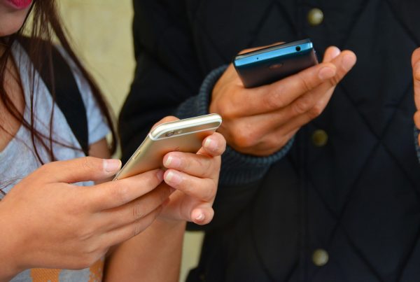 Two people using their mobile phones on a blog about phone scams